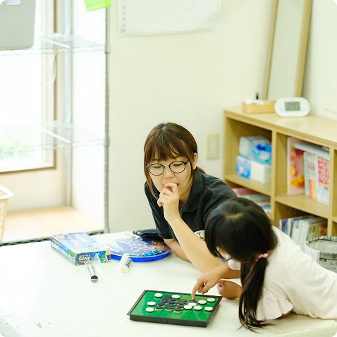 子供とオセロをする芹沢 菜月さん